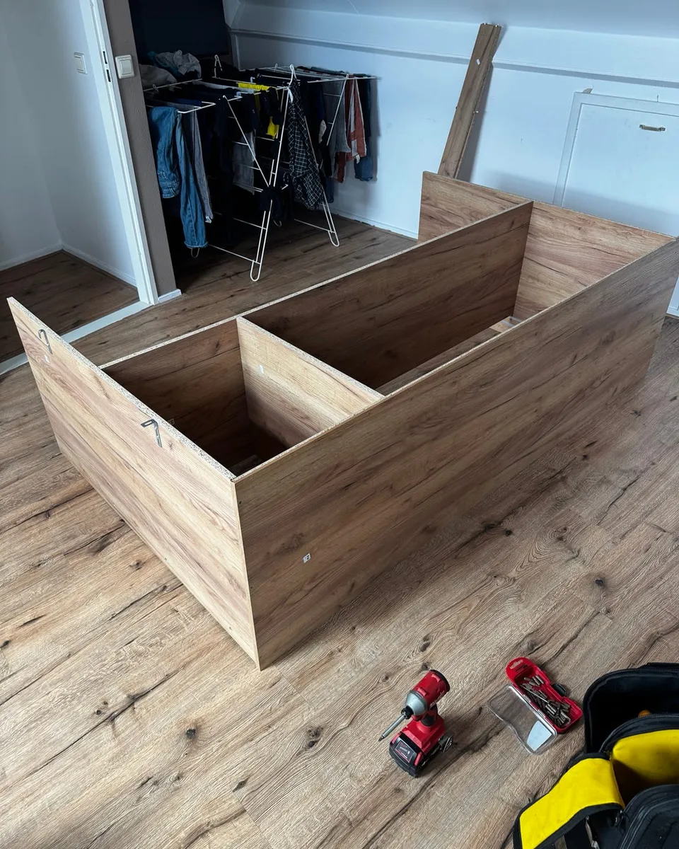 Het kastframe ligt tijdens de montage opengeklapt op de vloer, met gereedschap ernaast