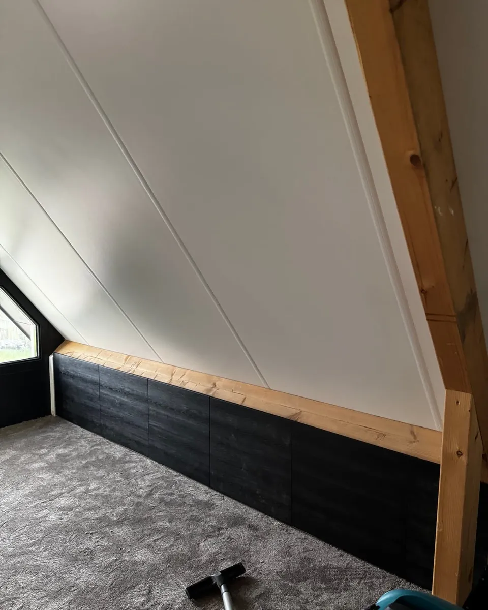 Het donkere knieschot met de houten aftimmerlat, doorlopend tot in de hoek van de kamer
