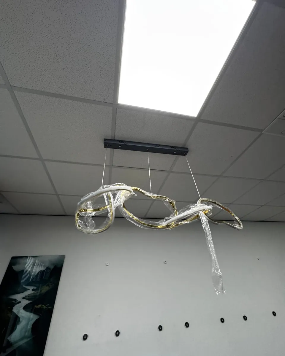 Het nieuwe armatuur hangt nog in de verpakking aan de montagebalk in het plafond