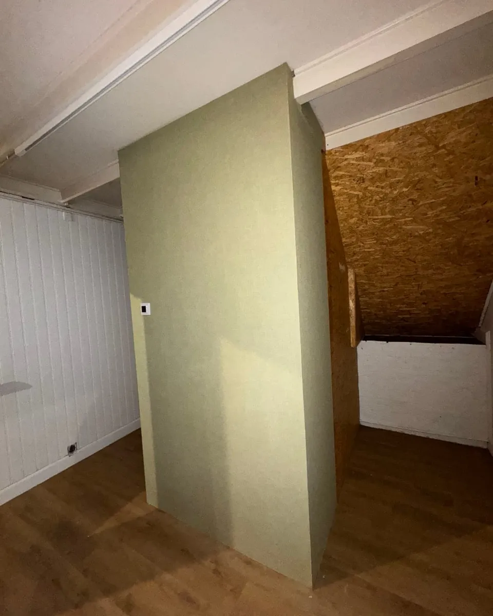 De nieuwe scheidingswand naast de wit gepaneelde wand en de houten vloer