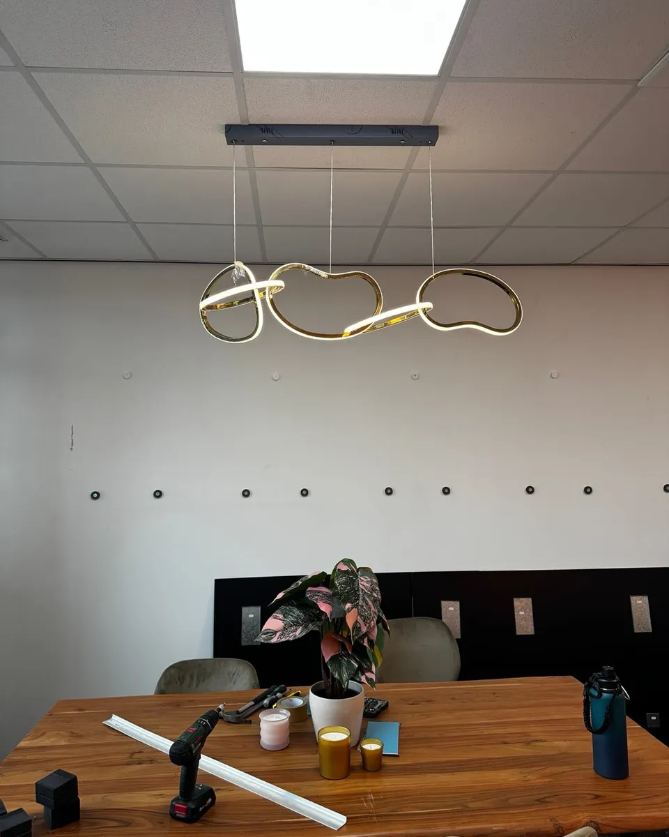 Lijnarmatuur met een doorlopende lichtlijn boven de vergadertafel